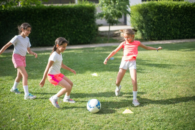 three s playing soccer in the grass