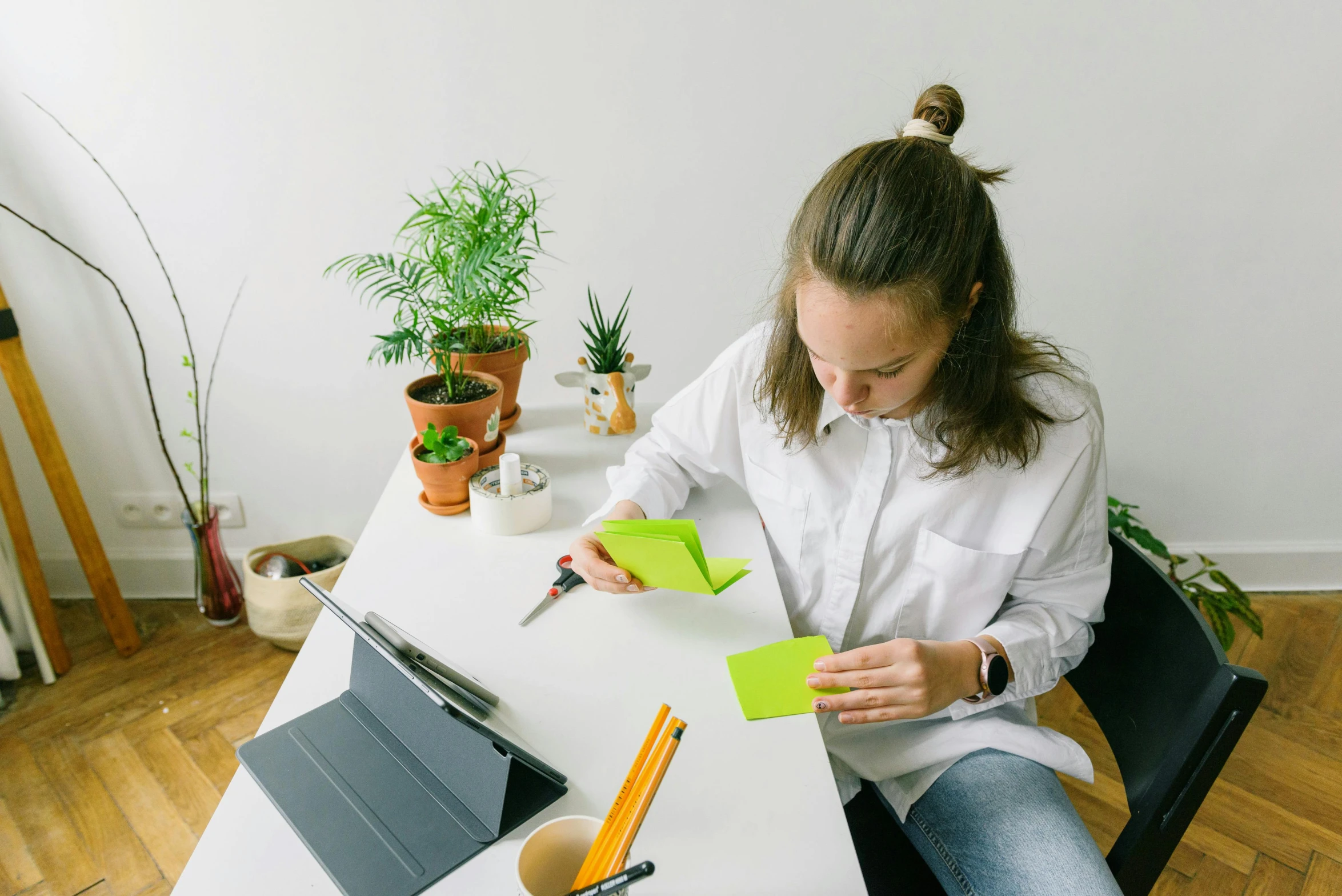 woman at desk with note and scissors