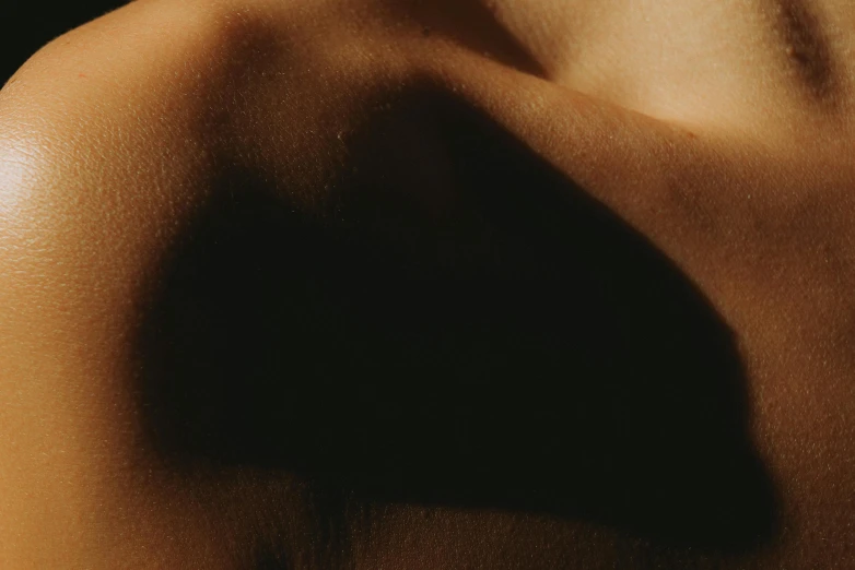 shadow of a woman's head and arm on a brown background