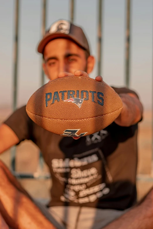 a man is holding a football while posing for a po