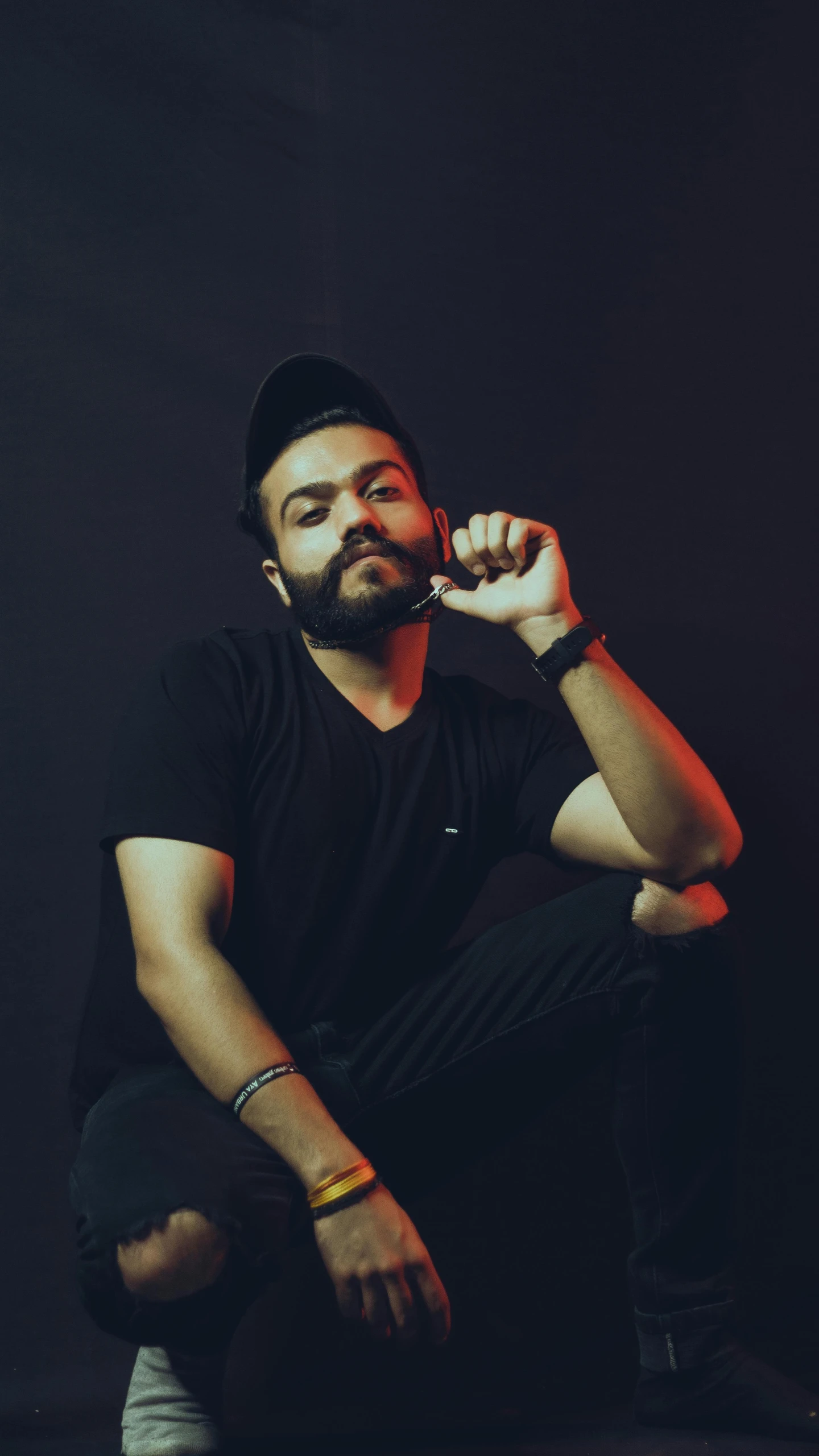 a man sitting in the dark posing for a po