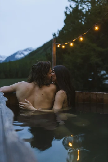 couple in a swimming pool surrounded by christmas lights