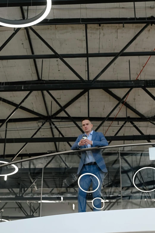 a man wearing a blue suit standing in a ceiling