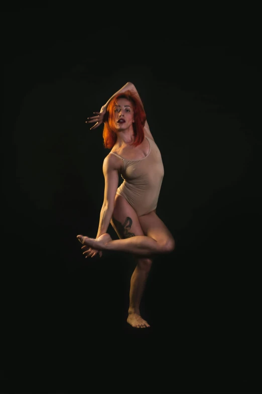 a red - haired woman is dancing while looking at the camera
