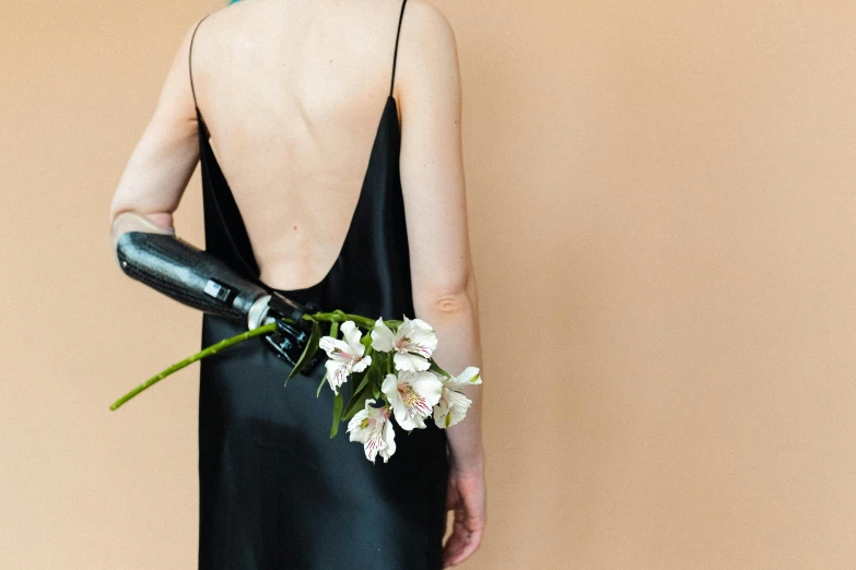 the back of a woman holding a large, flower bouquet