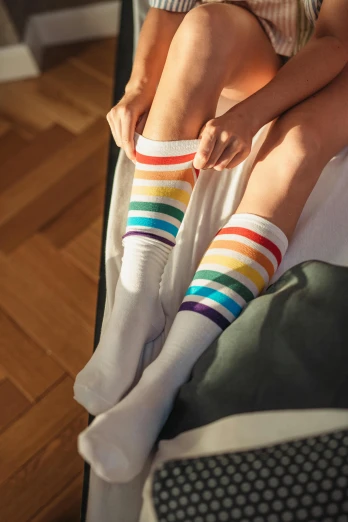 woman's feet with rainbow socks sitting on a couch