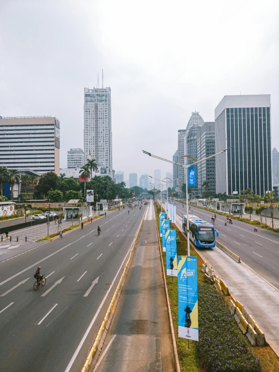 two cars driving down an empty highway with buildings in the background