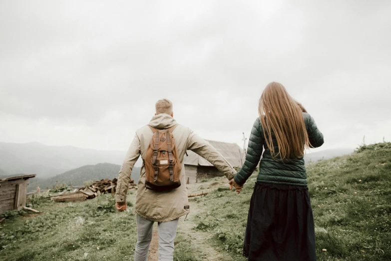 a woman walking on the grass with her arms around her back