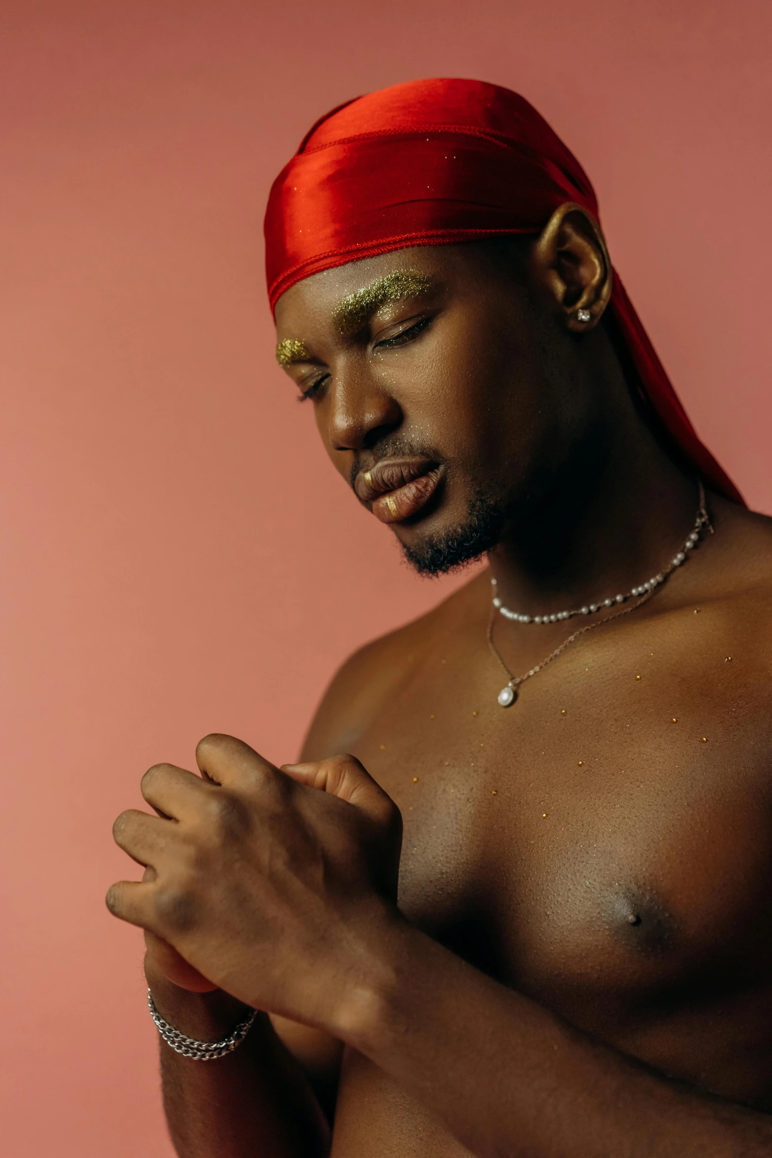 a man wearing a red turban holding his hands together