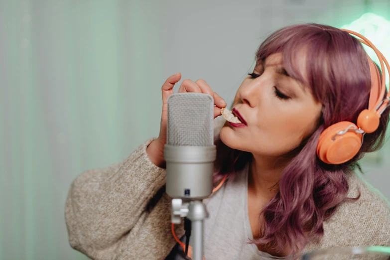 a girl in headphones is singing into a microphone