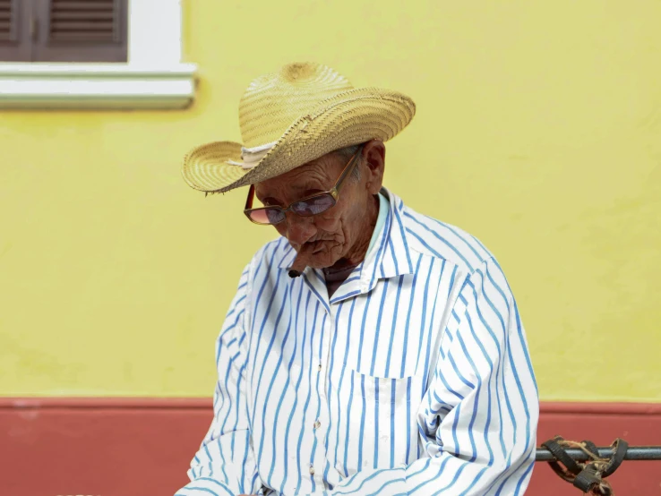 man wearing a striped shirt and straw hat