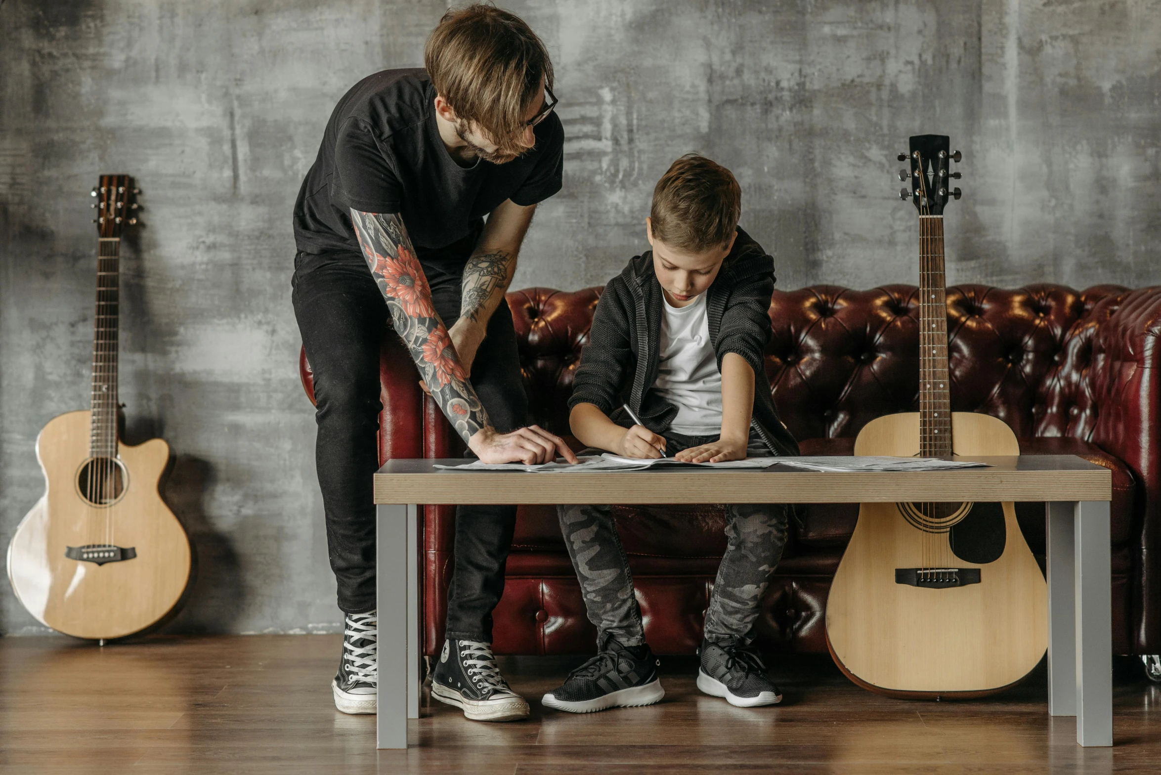 a person at a table with a guitar near another person