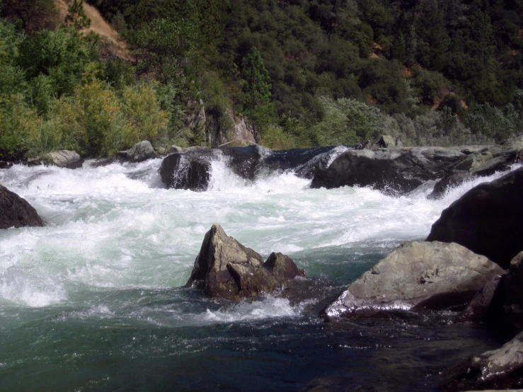 water and rocks in a mountain stream with grass on the side