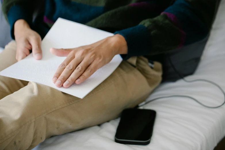 a person with a notepad in their lap sitting on a couch