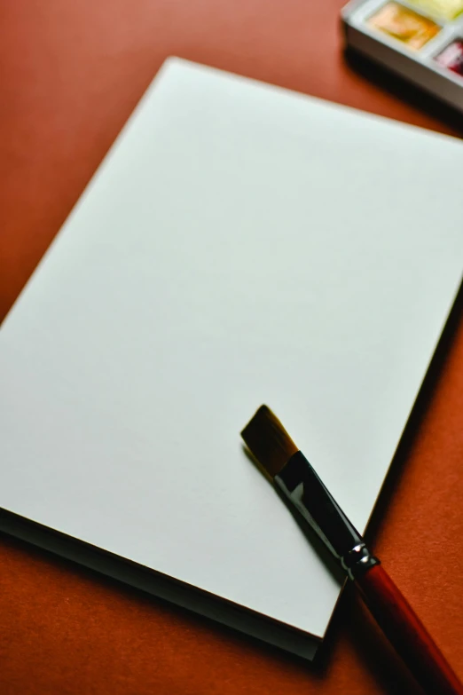 a red desk with a paper, pen and cell phone