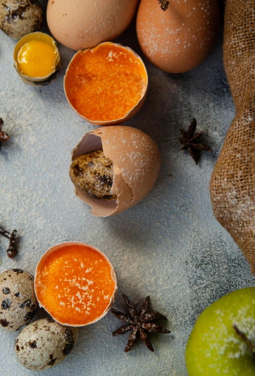 three quails and one orange juice sit near an egg shell