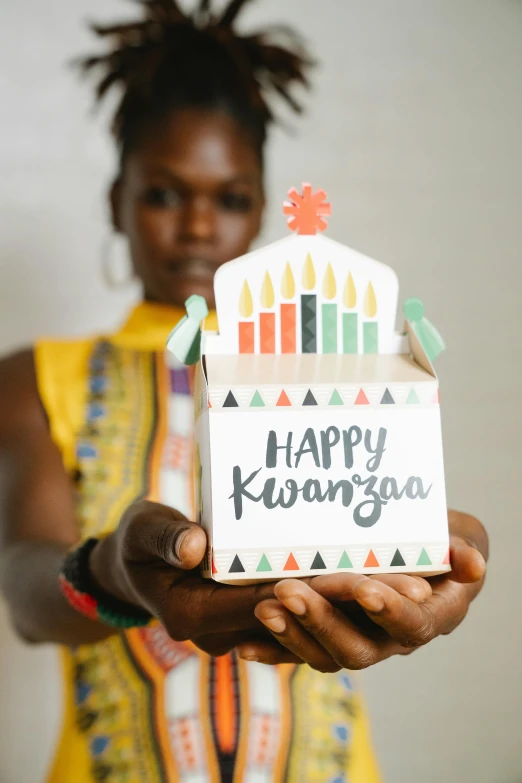 a young person holding a cake that has the words happy kannaga written on it