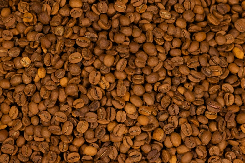 a close up of coffee beans in the shape of a background