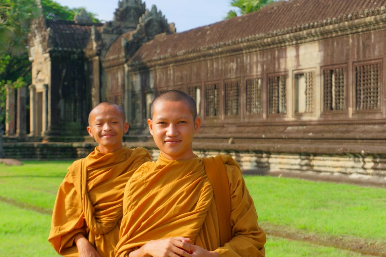 two monks stand in front of an old building