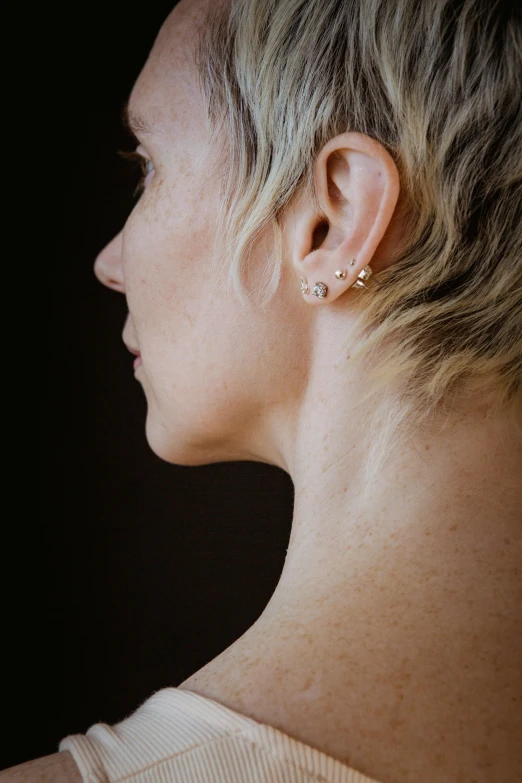 the back of a woman's head with ear piercings