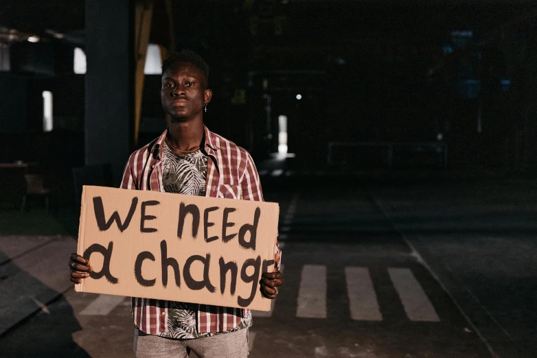 a man holding a sign while standing on a street