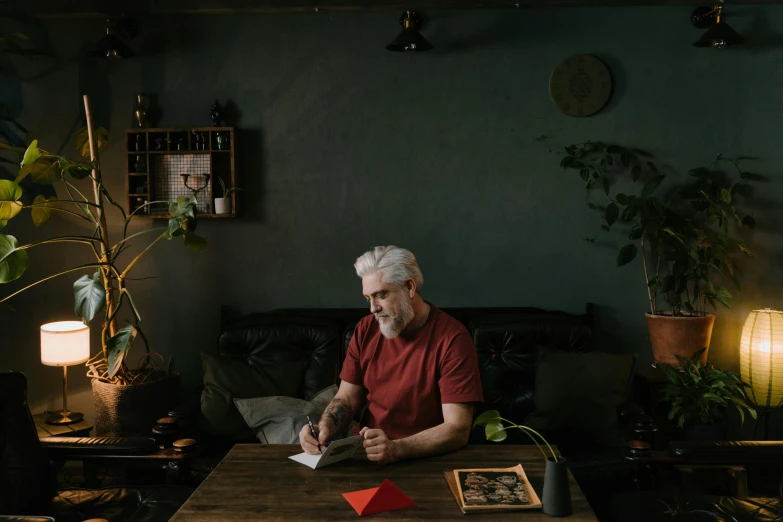 a man sitting at a table while reading a paper