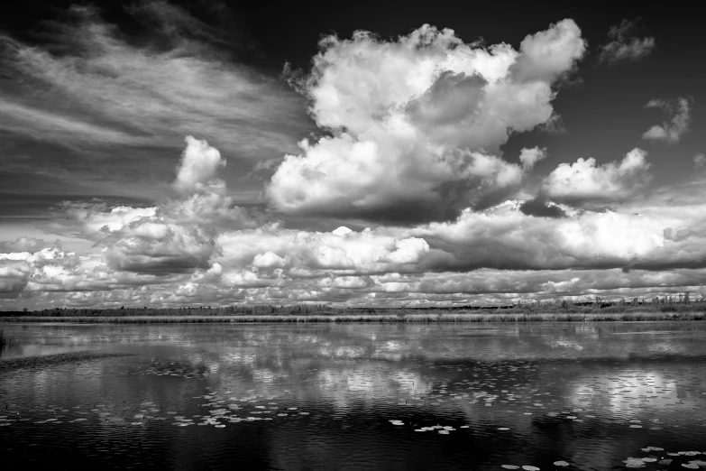 an ocean scene with a small boat and clouds in the sky