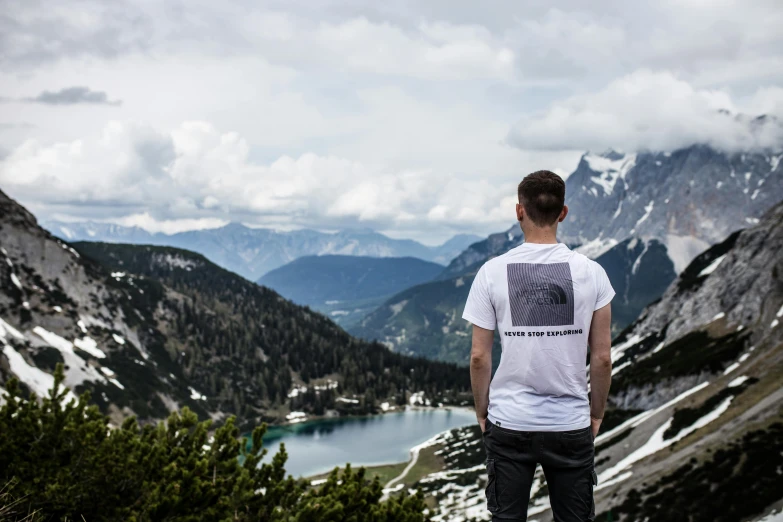 a man stands in front of mountains overlooking the mountains