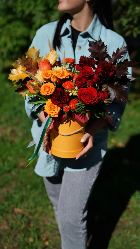 a woman holding a bunch of colorful flowers on her hand