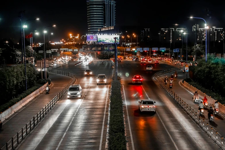 there are cars driving down the freeway at night