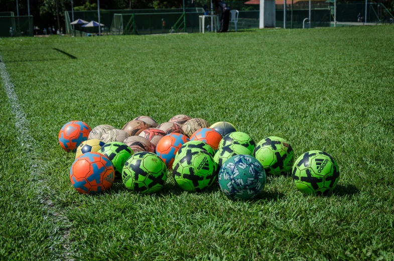 several colorful balls lined up on the soccer field