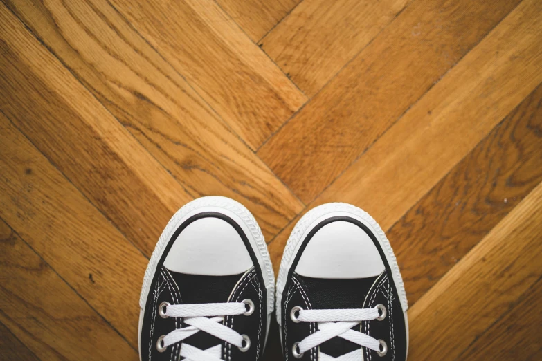 an empty black and white pair of shoes is sitting on the floor