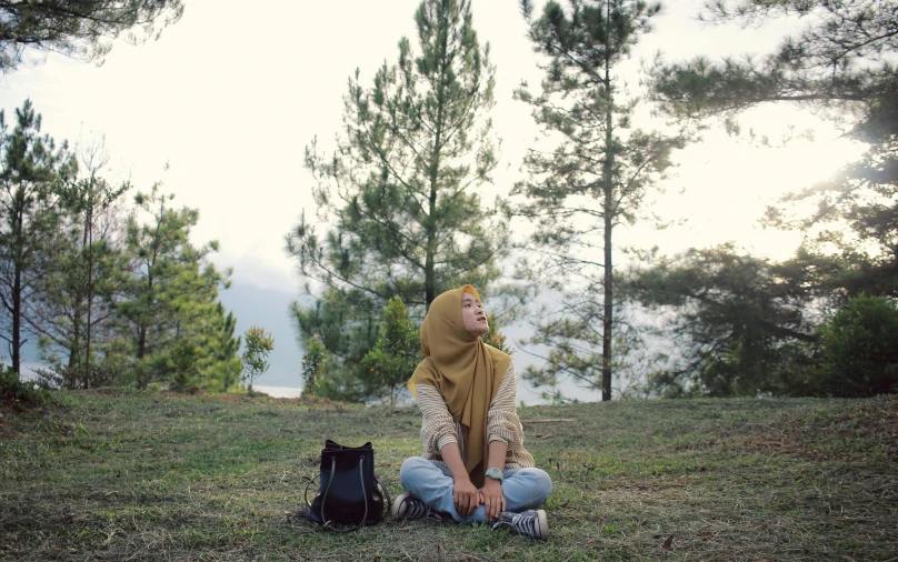 the girl is sitting alone in the forest