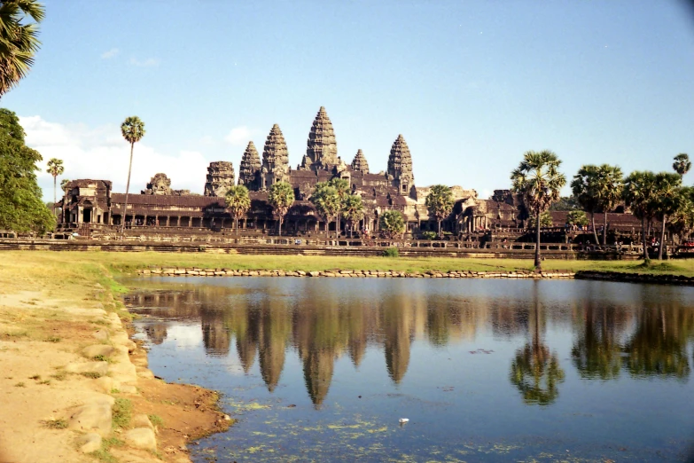 the palace stands tall over the water and has palm trees