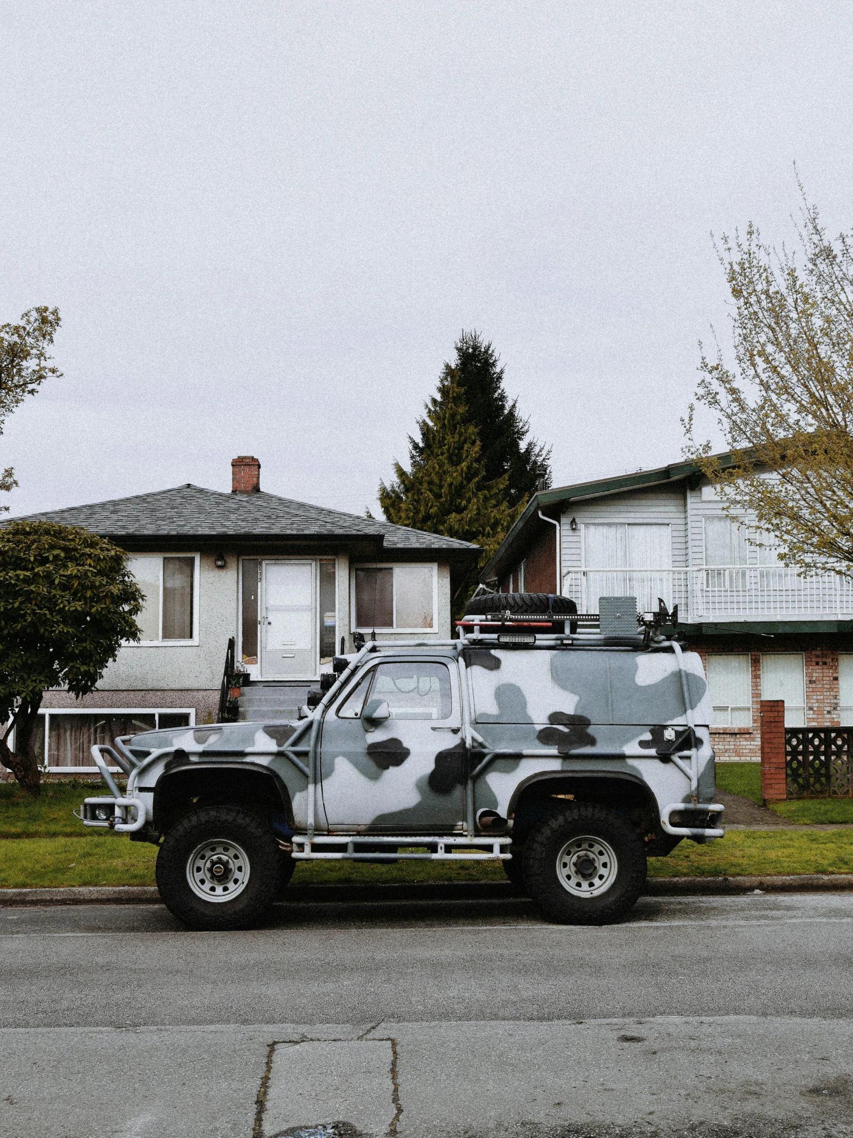 military vehicle painted with paint and some buildings in background