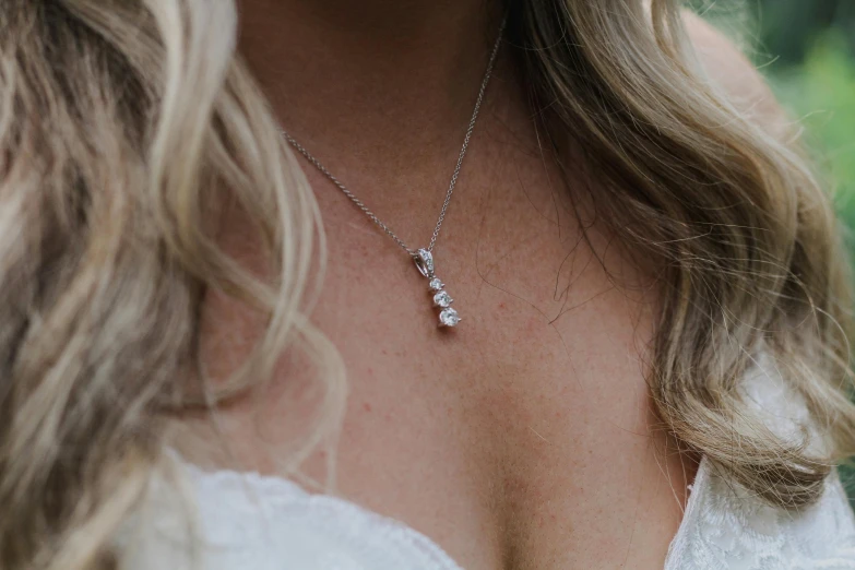 a close up of a woman wearing a white dress and necklace