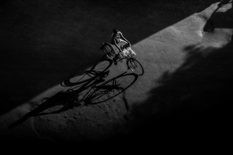 the shadow of a person riding on a bike