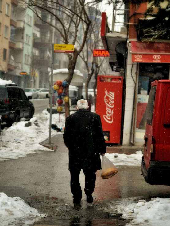 a man is walking down the street in the snow