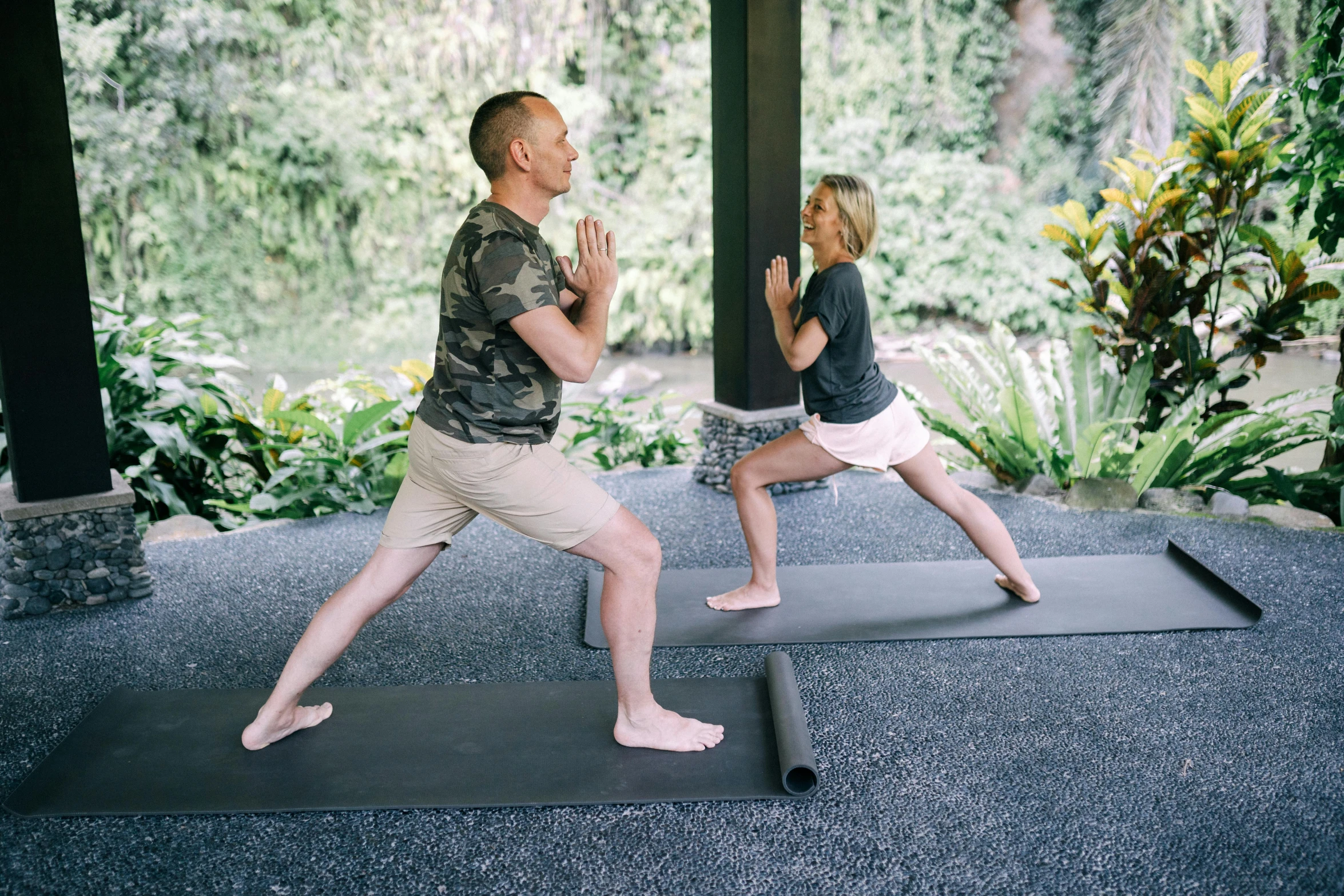 a man and woman practicing yoga together outside