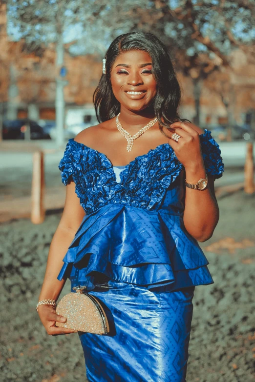 a woman in a blue dress smiles and poses