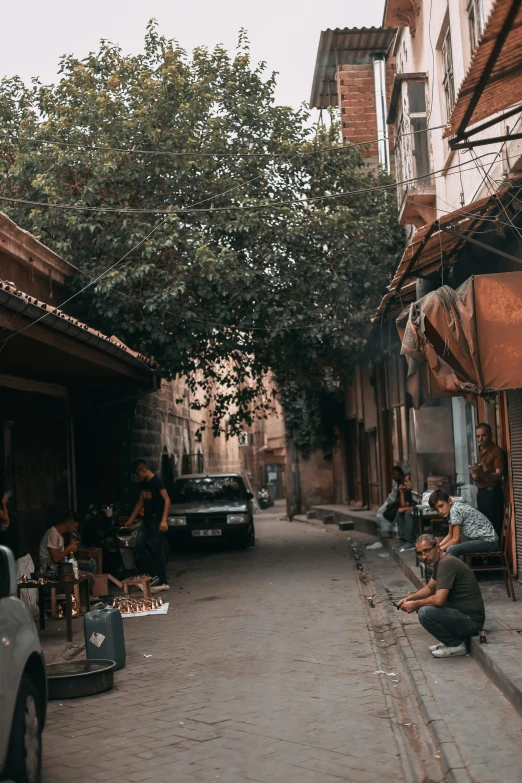 some people sitting and standing in the road outside