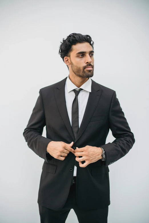 man in business suit adjusting his necktie