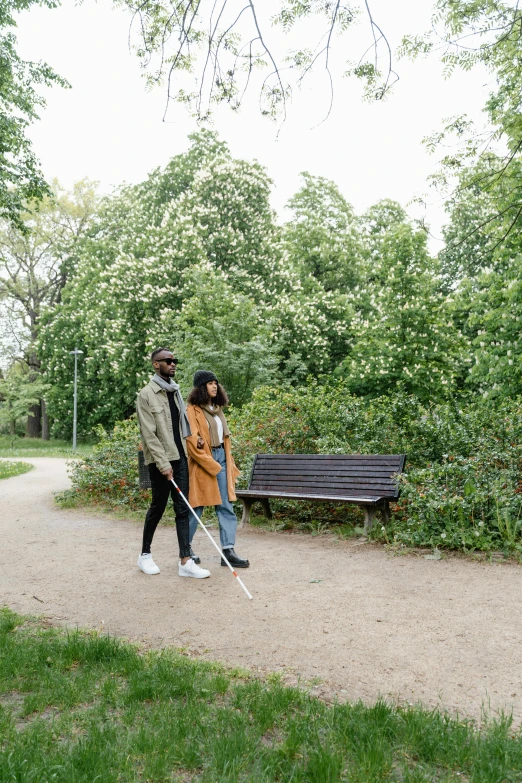 the two people are walking through the park