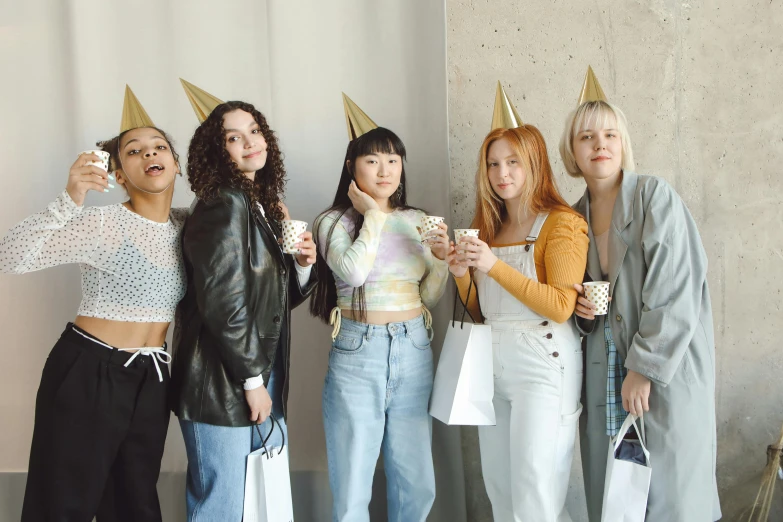 four girls wearing party hats in the corner