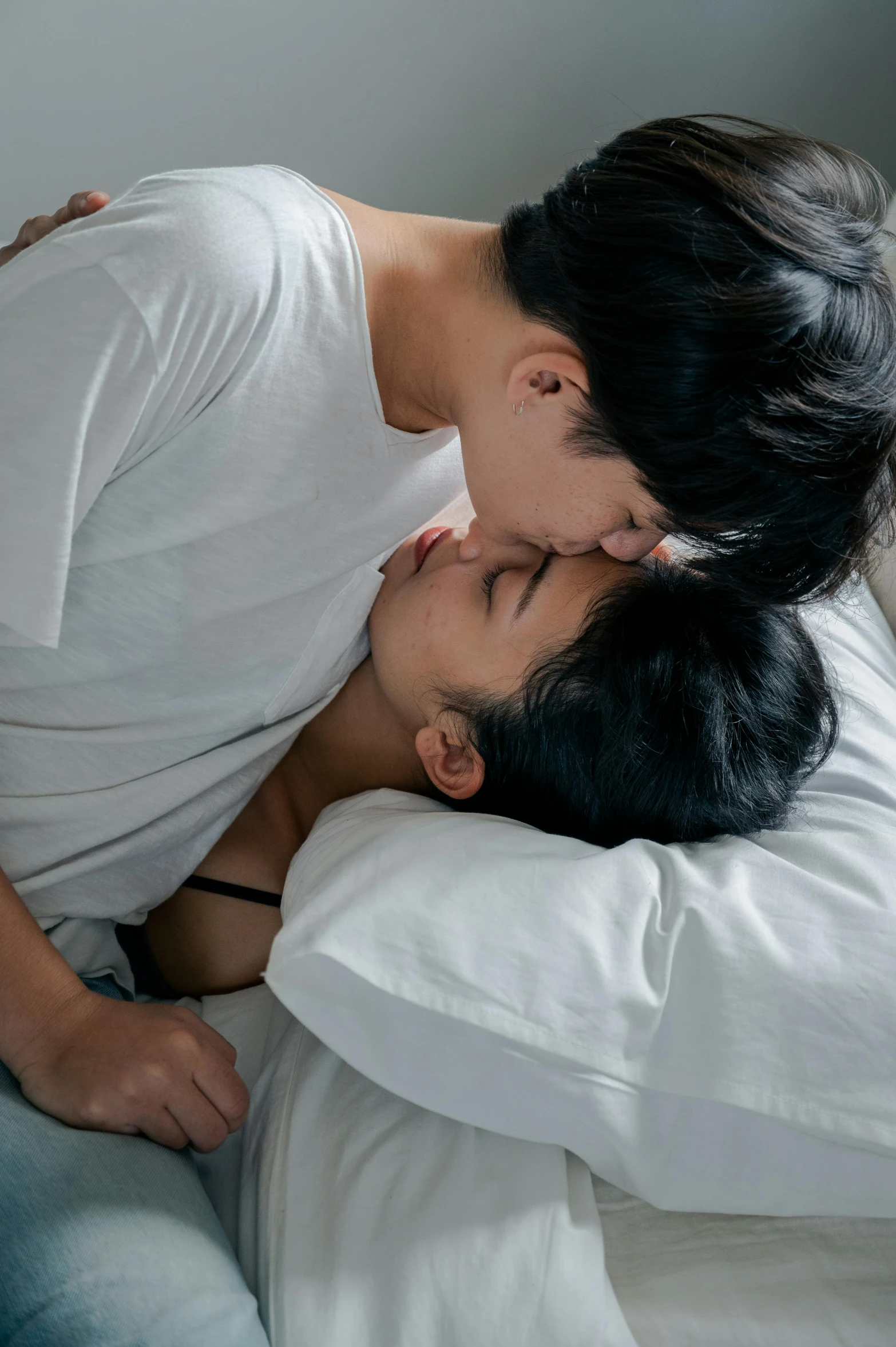 a man and a woman laying next to each other in bed