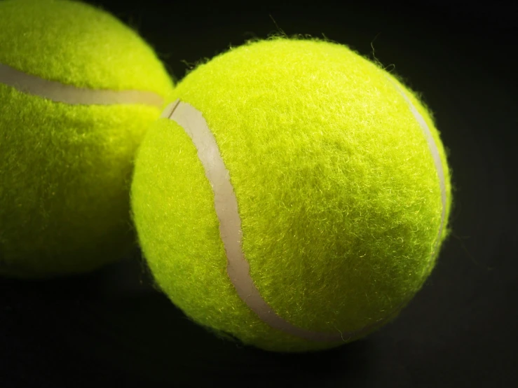two tennis balls are stacked on top of each other