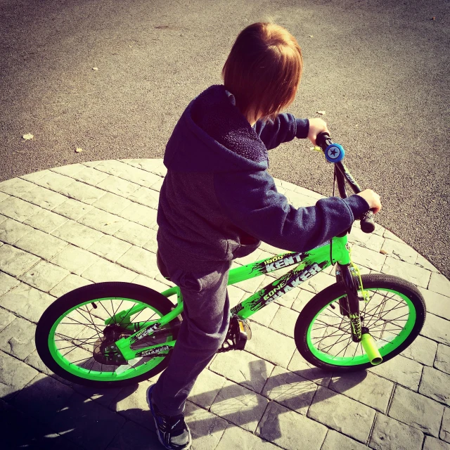 a  rides his bike on a brick walkway