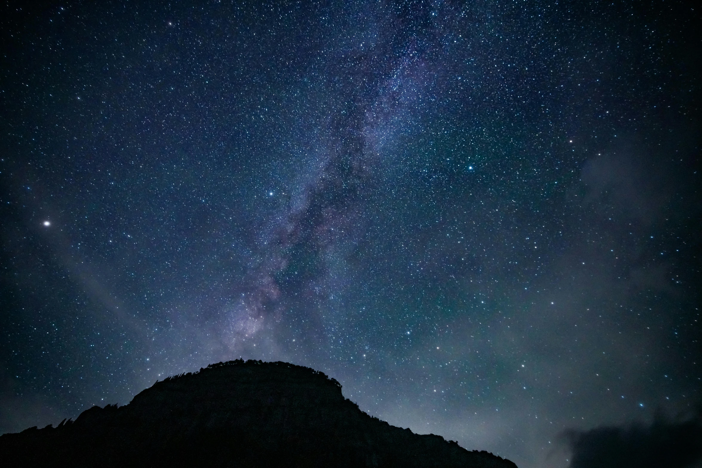 a mountain under a night sky with stars