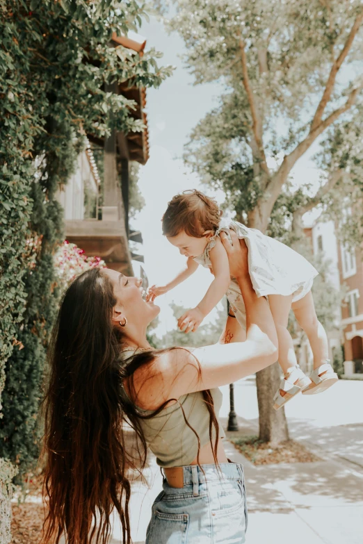 the young lady is holding up her small child