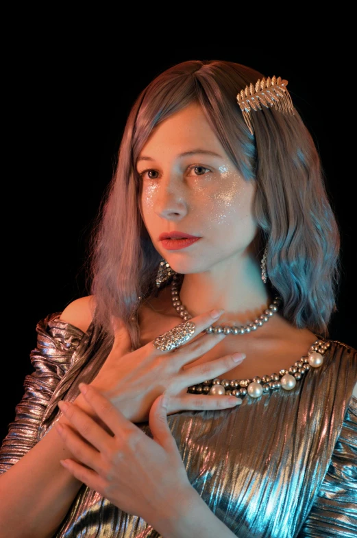 a woman in a golden gown with a necklace and pearl tiara